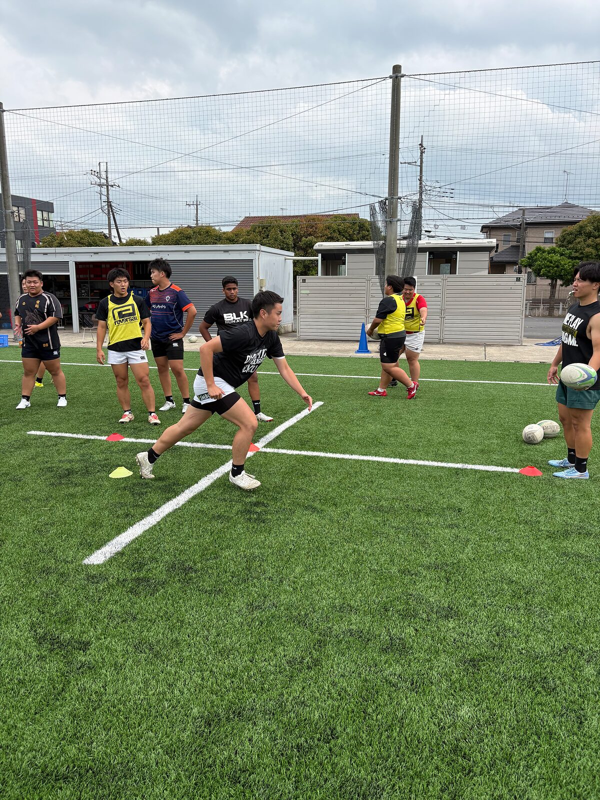 曇り空のグラウンドでパス練習をする選手たち