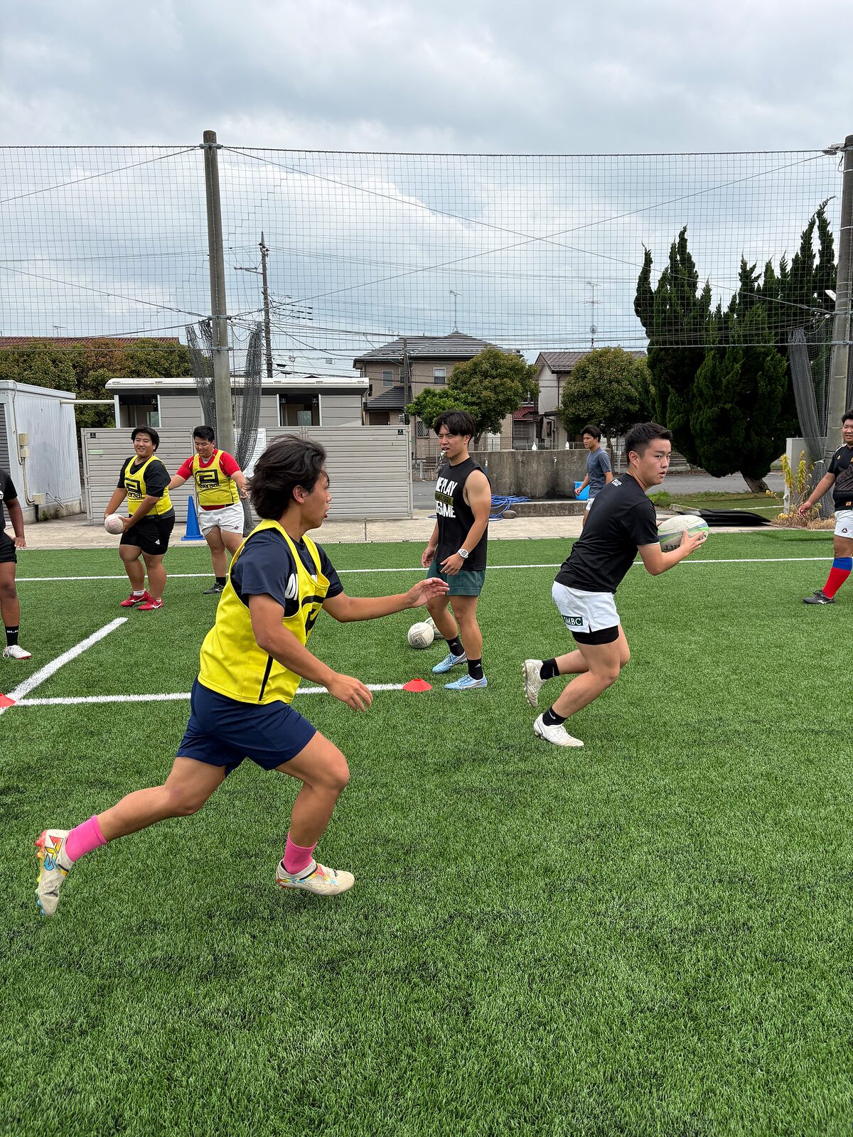 ビブスを着てボールを持ち走る選手