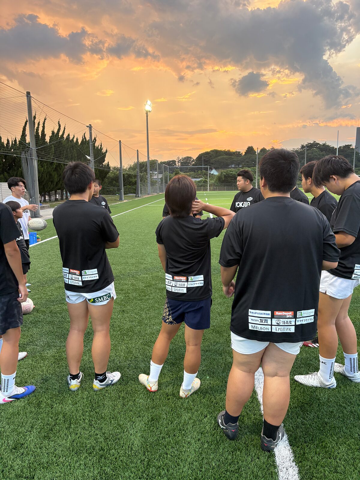夕焼け空の下で集まる選手たち